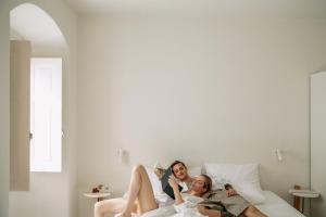 a group of three people laying on a bed at Ammothines Cycladic Suites in Naxos Chora