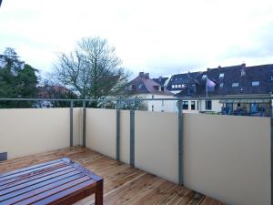 d'un balcon avec une clôture blanche et un banc en bois. dans l'établissement 75 m2, zentral, Küche, Balkon, Parkplatz, à Osnabrück