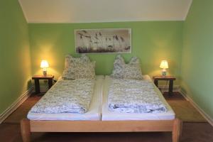 two beds in a room with green walls and two lamps at Bensdorfer Mühle - Auszeit in Brandenburg in Bensdorf