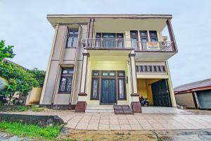 Casa grande con balcón en la parte superior. en OYO 92177 Arafah Homestay Syariah en Bangkinang