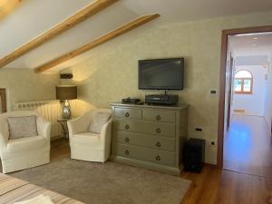 sypialnia z komodą z telewizorem i dwoma krzesłami w obiekcie Holiday Home Valmoneda w Rovinj