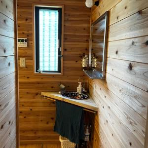 ein Badezimmer mit einem Waschbecken in einer Holzhütte in der Unterkunft Eco Lodge Moss Tasha - Vacation STAY 39871v in Yakushima