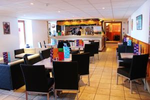 a restaurant with tables and chairs and a counter at VVF Jura Les Rousses in Prémanon