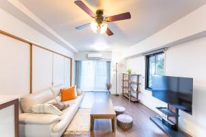 a living room with a couch and a flat screen tv at VIVI熱海 自然郷 3001丨VIVI Atami Shizenkyo 3001 in Atami
