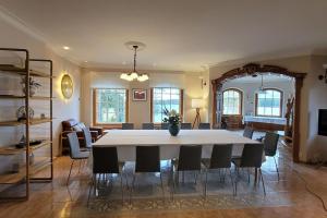 uma sala de estar com uma grande mesa branca e cadeiras em Pinecrest Villa - Castle style living on seaside em Porvoo