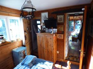 a living room with wooden walls and a tv at NELSONS CABIN in North Creake +17 photos