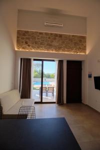 シヴォタにあるZefiros Luxury Apartmentsのリビングルーム(ソファ付)が備わり、パティオの景色を望めます。
