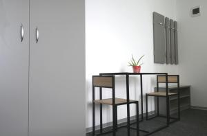 奧托佩尼的住宿－Luana Airport Apartments #8，一张桌子和两把椅子,靠墙