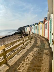a row of colorful beach houses on a beach at 18 Duckpool in Kilkhampton