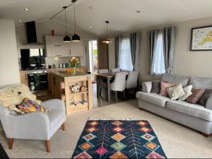 a living room with two couches and a kitchen at 18 Duckpool in Kilkhampton
