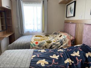 a bedroom with two beds and a window at 18 Duckpool in Kilkhampton