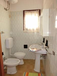 比比翁的住宿－Welcoming accommodation in Bibione - Beahost，白色的浴室设有卫生间和水槽。