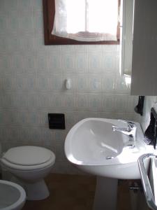 比比翁的住宿－Welcoming accommodation in Bibione - Beahost，浴室配有白色水槽和卫生间。