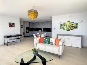 een woonkamer met een witte bank en een tafel bij Francelho 1 Apartment by LovelyStay in Ribeira Brava
