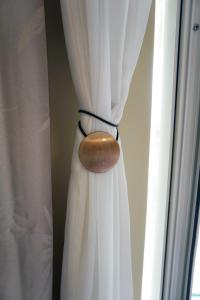 a close up of a white curtain with a wooden button at Holiday House Terezija in Baška Voda