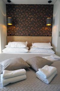 a bed with three pillows on top of it at Holiday House Terezija in Baška Voda