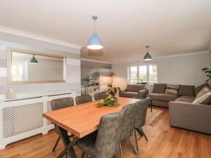 a kitchen and living room with a wooden table and chairs at Rainbow View in Taunton