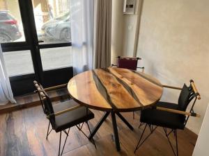 una mesa de madera y sillas en una habitación con ventana en Tzfat Boutique Stay! en Safed