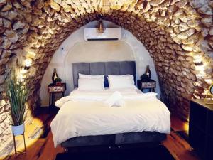 a bedroom with a large bed in a stone wall at Tzfat Boutique Stay! in Safed