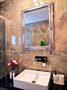 y baño con lavabo blanco y espejo. en Sveltos Residence Suites en Lárnaca
