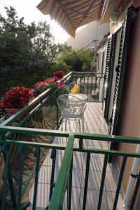 a balcony with a table and flowers on it at Holiday House Terezija in Baška Voda