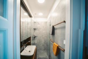 a bathroom with a sink and a shower at Volenter Lux Apartment Zero in Baja