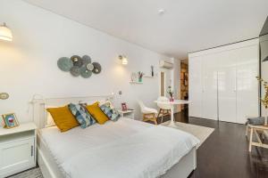 a white bedroom with a large bed and a table at Taylors apartment by Innkeeper in Vila Nova de Gaia