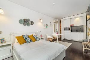 a white bedroom with a large bed and a kitchen at Taylors apartment by Innkeeper in Vila Nova de Gaia