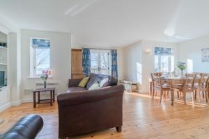 ein Wohnzimmer mit einem Sofa und einem Tisch in der Unterkunft Fisherman's Cottage in Somerford Keynes