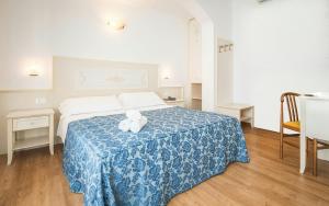 a bedroom with a bed with two teddy bears on it at Hotel Principe in Caorle