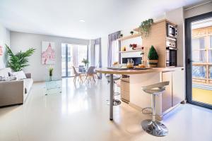 una cucina e un soggiorno con tavolo e sedie di CARTAGENAFLATS, Apartamentos Calle Mayor II, PREMIUM FLATS CITY CENTER a Cartagena