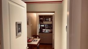 einen Flur zu einer Küche mit einem Tisch und einer Mikrowelle in der Unterkunft Residenza Le 6 A in Triest
