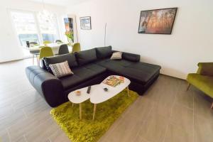 a living room with a black couch and a table at Ferienwohnung Landurlaub in Irsch