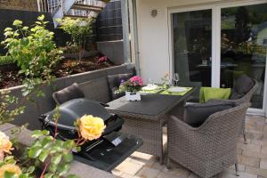 a patio with a table and chairs and a grill at Ferienwohnung Landurlaub in Irsch