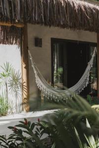 eine Hängematte, die an der Seite eines Hauses hängt in der Unterkunft CASA SUKHA Hotel in Trancoso