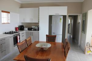 a kitchen with a wooden table with a bowl on it at WILDERNESS SEASIDE ESCAPE in Wilderness +15 photos