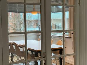 una mesa y sillas son vistas a través de una ventana en Central lejlighed i Herning, en Herning