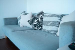 a blue couch with many pillows on it at Wax Hostel in Faro