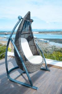 a hanging chair on a deck with a view of the ocean at Wax Hostel in Faro