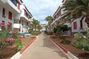 una passerella di fronte a un edificio con palme di Altemar in las Américas ad Arona