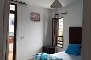 una camera da letto con un letto con un cuscino blu e una finestra di Altemar in las Américas ad Arona Altre 22 foto