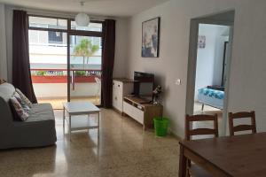 un soggiorno con un divano, un tavolo e una televisione di Altemar in las Américas ad Arona