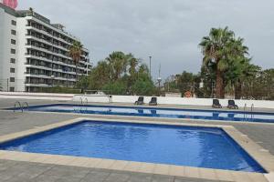 una grande piscina con sedie accanto a un edificio di Altemar in las Américas ad Arona