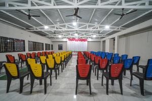 a row of chairs in a room with colorful chairs at Hotel Saheb in Kolhapur