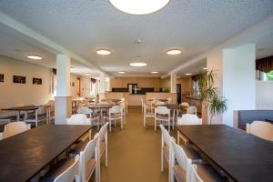 a dining room with tables and white chairs at Sportschule Werdau in Werdau