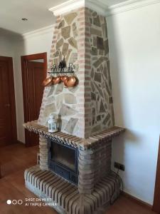 a stone fireplace in a living room at Casa Rosas in Vélez-Málaga
