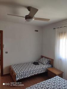 1 dormitorio con 2 camas y ventilador de techo en Casa Rosas, en Vélez-Málaga