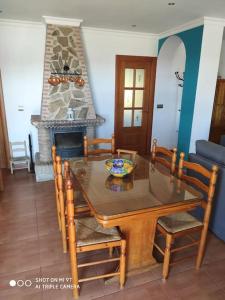 a dining room with a table and a fireplace at Casa Rosas in Vélez-Málaga