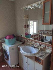 y baño con lavabo y lavadora. en Casa Rosas, en Vélez-Málaga