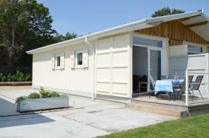 a small house with a patio and a table at Lake Lodges in Chichester